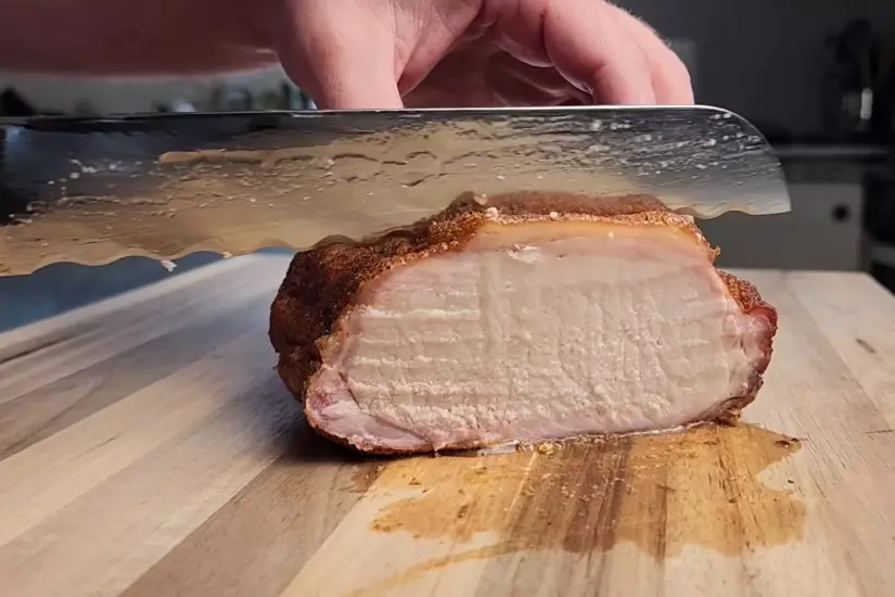 cutting cooked meat with a bread knife